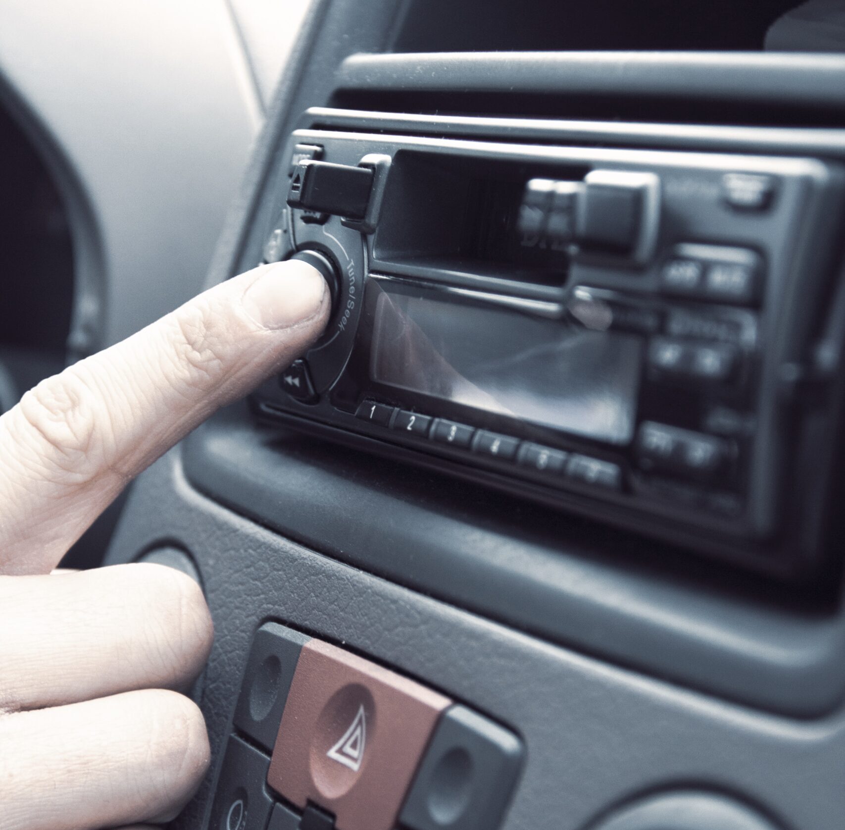 Radio in your marketing mix - person selecting a radio station in a car