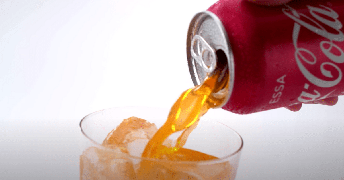 The coke is fanta - A can of coke pouring orange fanta into a glass.